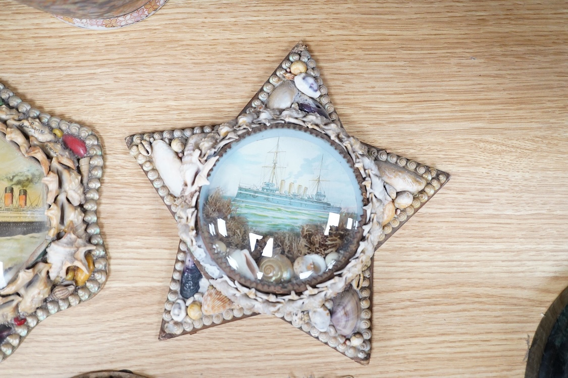 A collection of seven shellwork frames with convex glass, housing maritime interest prints with seaweed and shell decoration, largest 23cm in diameter